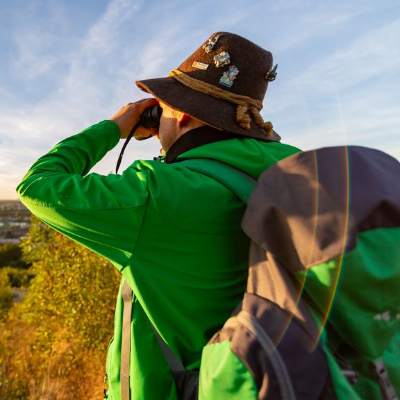 Wanderer schaut durch ein Fernglas