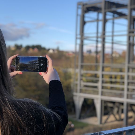 Junge Frau fotografiert mit ihrem Handy den Wassergarten in Reden